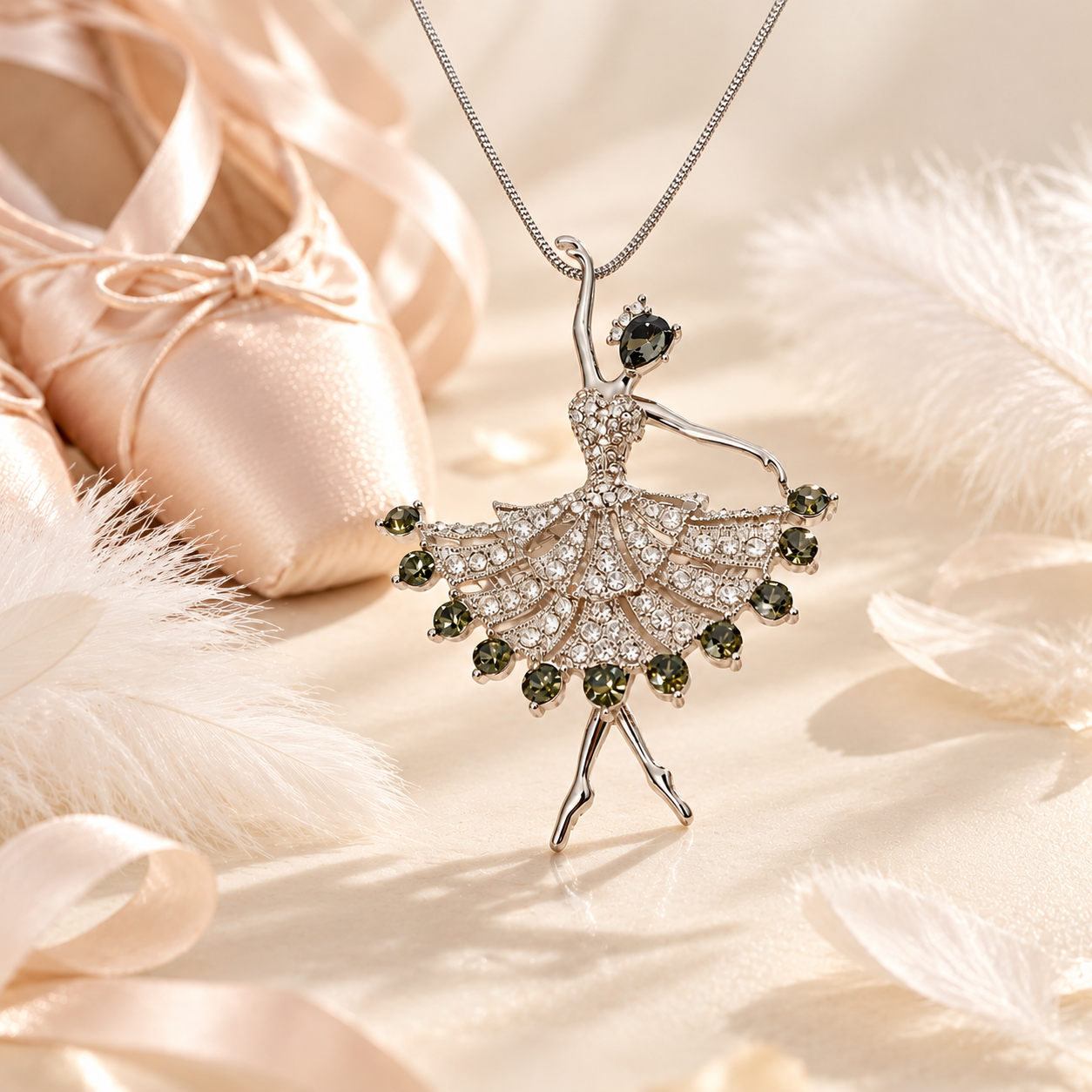 Crystal ballerina pendant necklace beside satin pointe shoes and white feathers, a gift for ballet dancers
