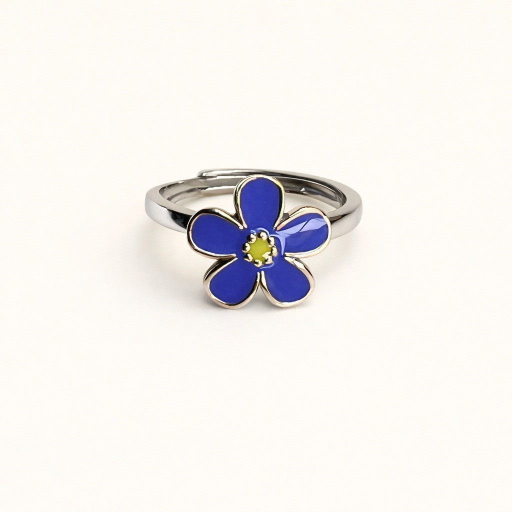 Silver ring with a blue flower-shaped design on a white background