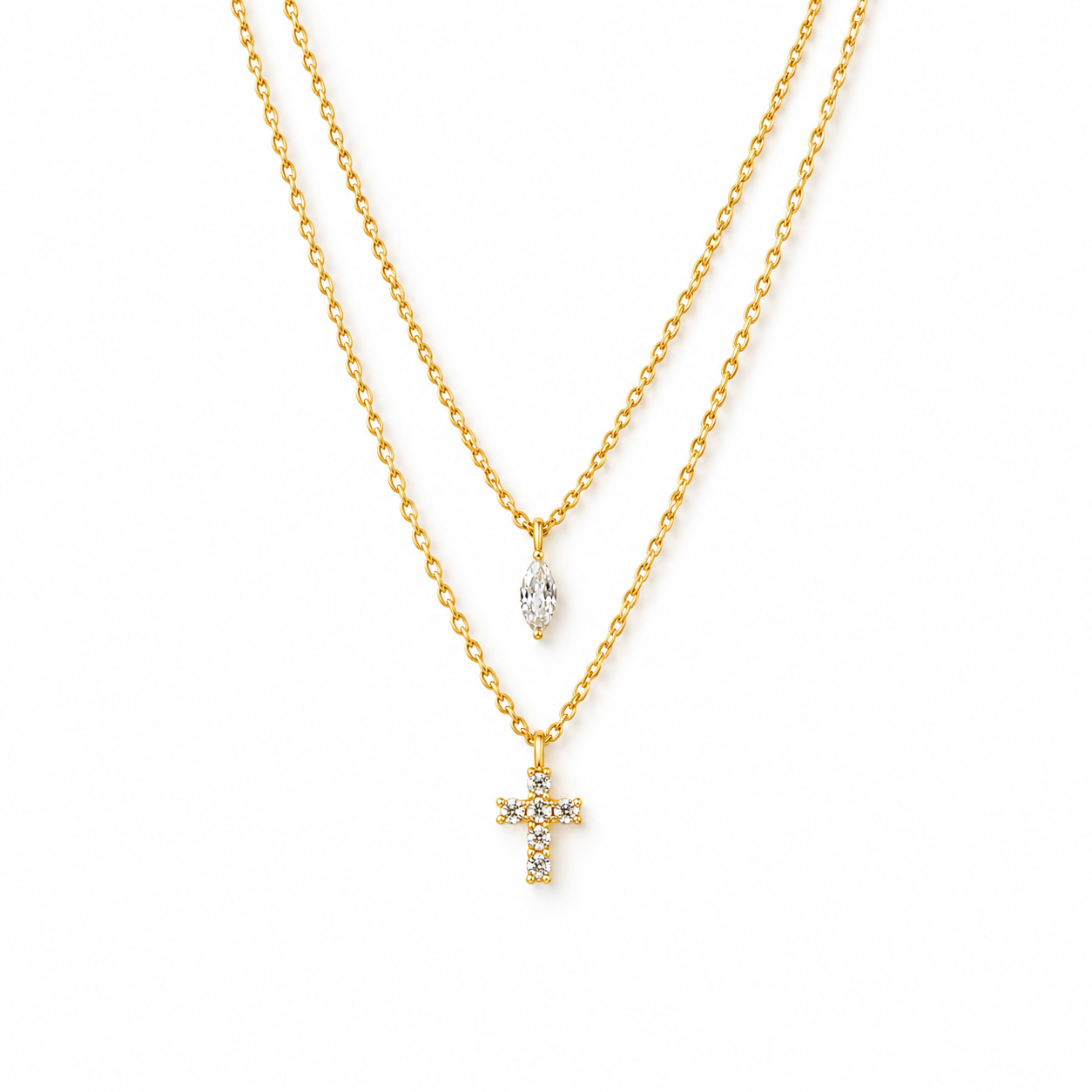 A double-strand gold necklace featuring a small marquise-cut clear stone pendant on the top chain and a gold cross pendant adorned with small clear stones on the bottom chain, shown against a plain white background.