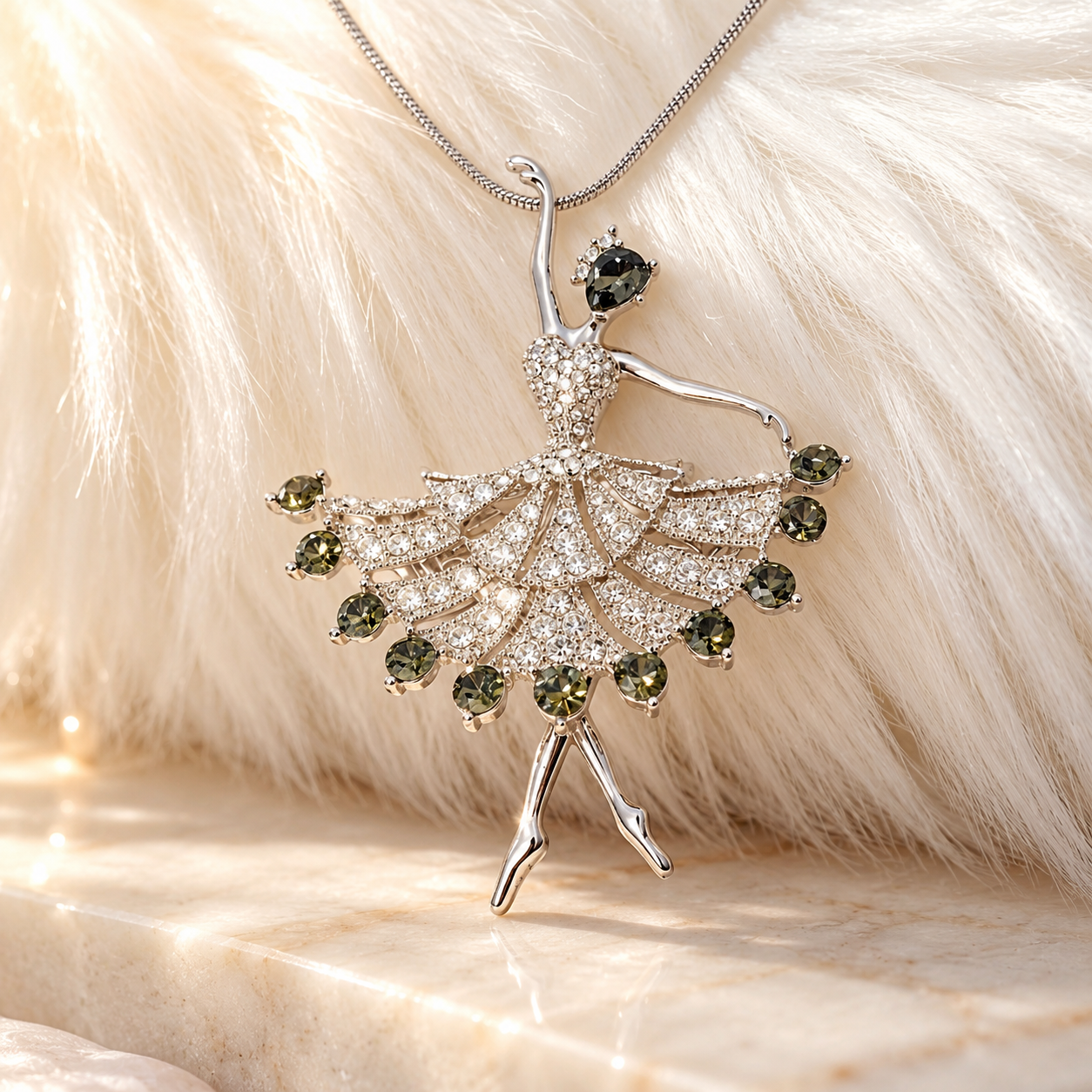 Emerald Prima crystal ballerina pendant necklace in silver tone with olive green crystals, displayed on soft white fur